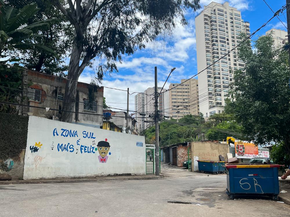 Muro branco com desenho de um homem e ao lado a frase "a zona sul é mais feliz"